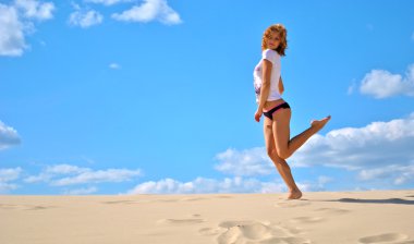 seksi güzel kadın modeli oturur ve külot yalnız teşkil çölün ortasında poz veriyor