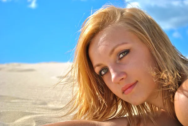 Face of a young beautiful girl who poses on the sand — Stock Photo, Image