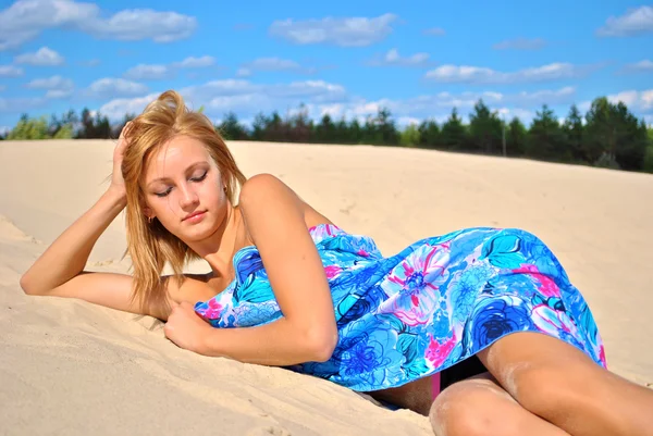 Mooie seksuele naakte blond model bedekt met een blauw weefsel op het zand — Stockfoto