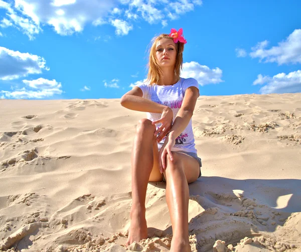 Дивовижна сексуальна блондинка сидить на піску показує свої навички позування в пустелі — стокове фото
