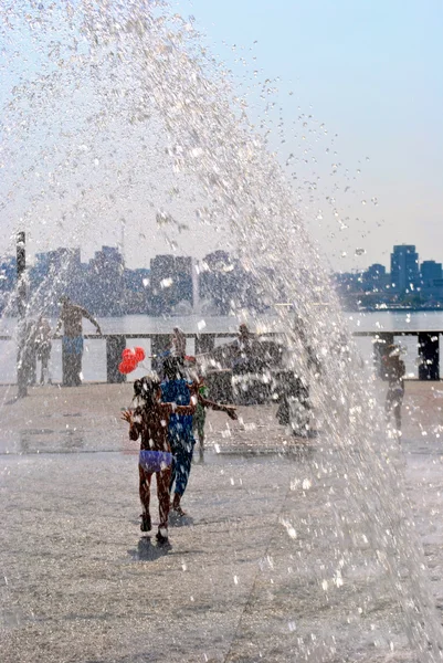 Los niños juegan en una fuente de la calle durante las vacaciones — Foto de Stock