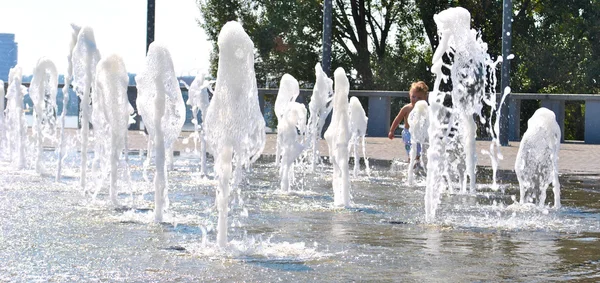 Petit enfant joue dans une fontaine de rue pendant les vacances — Photo