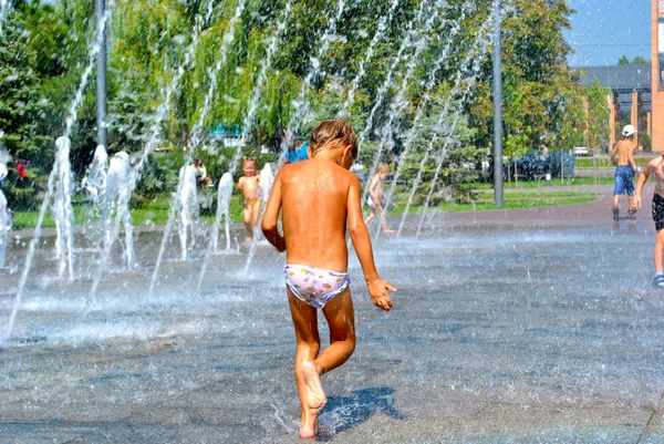 Malé dítě hraje v ulici fontána během dovolené — Stock fotografie
