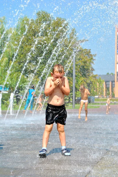 Bambino gioca in una fontana di strada durante la vacanza — Foto Stock