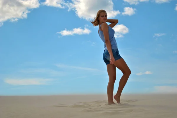 Linda modelo loira sexual fica na areia em um dia brilhante — Fotografia de Stock