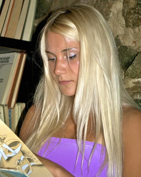 Menina bonita lê em um restaurante de moda antiga — Fotografia de Stock