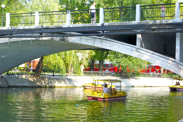 Spaziergang auf dem Wasserrad unter der Brücke über den See im Park — Stockfoto