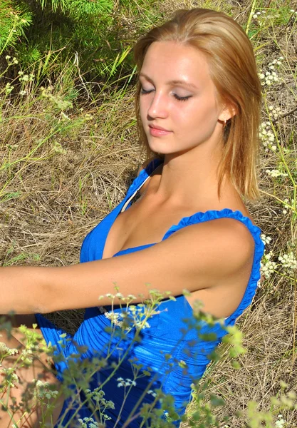 Linda loira modelo feminino senta-se na grama e posa — Fotografia de Stock
