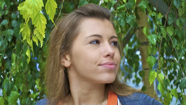 Portrait d'une jolie fille rousse avec les feuilles comme arrière-plan — Photo