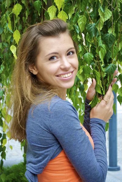 Pěkný rusovlasá dívka drží větve s listy — Stock fotografie