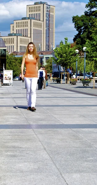 Piękna rudowłosa dziewczyna w shirt pomarańczowy spacery po mieście — Zdjęcie stockowe