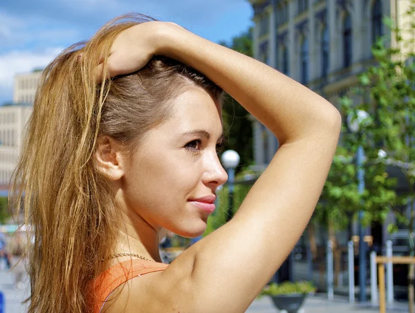 Hermosa chica caucásica pelirroja en una camisa naranja posa con la mano en el pelo —  Fotos de Stock