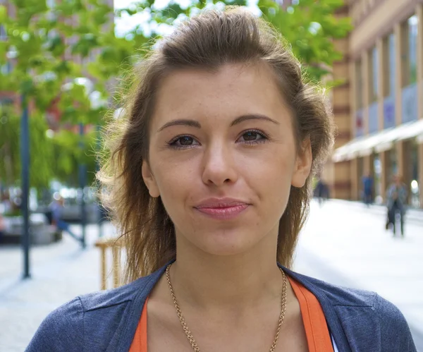 Chica joven pelirroja con una camisa naranja y la ciudad —  Fotos de Stock