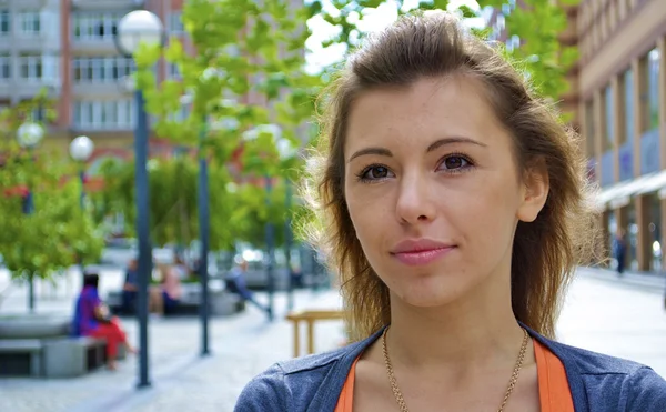 Ragazza dai capelli rossi con una camicia arancione e la città — Foto Stock