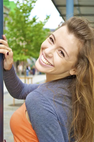 Belle jeune fille aux cheveux roux en chemise orange pose près d'un lampadaire — Photo