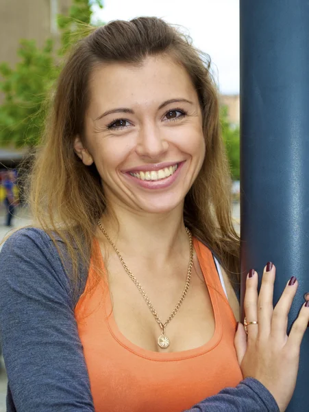Krásná rusovlasá mladá dívka v oranžové tričko představuje u lampy post — Stock fotografie