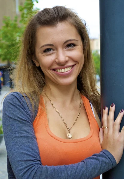 Hermosa joven pelirroja con una camisa naranja posa cerca de un poste de luz en Ucrania —  Fotos de Stock