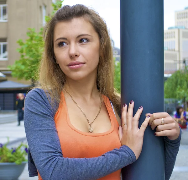 Bella ragazza dai capelli rossi in una camicia arancione posa vicino a un lampione in Ucraina — Foto Stock