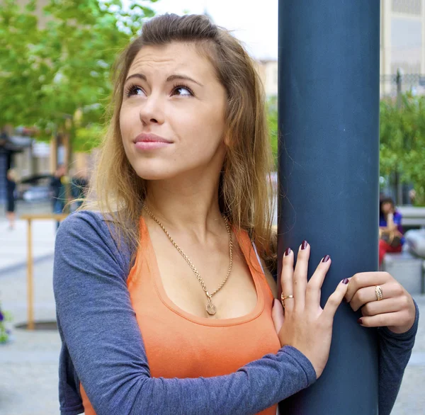 Mooie roodharige meisje in een oranje shirt met zich meebrengt in de buurt van een lantaarnpaal in Oekraïne — Stockfoto