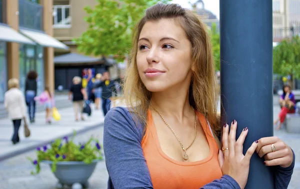 Krásná rusovlasá mladá dívka v oranžové tričko představuje u lampy na Ukrajině — Stock fotografie