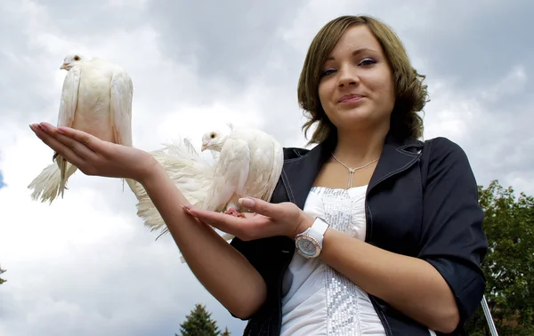 Mignonne fille russe tient deux pigeons blancs dans ses mains — Photo