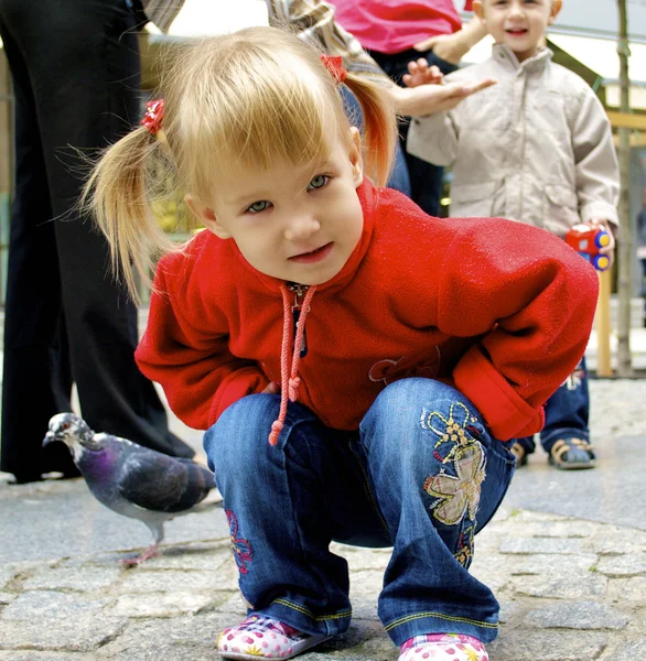 Söt liten flicka sitter på marken — Stockfoto