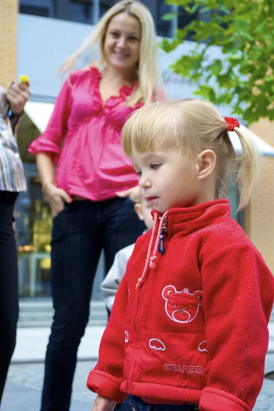Kleines süßes Mädchen in roter Jacke — Stockfoto
