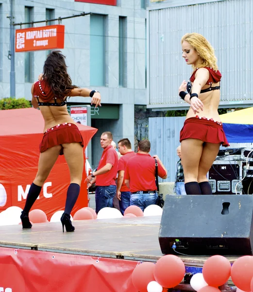 Two Russian sexy girls dance in red clothes during the city holiday and promotion of new brand — Stock Photo, Image