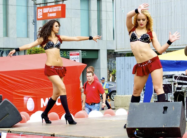 Два російських сексуальні дівчата танцюють у червоні одягу під час міського свята і розкрутку нового бренду — стокове фото