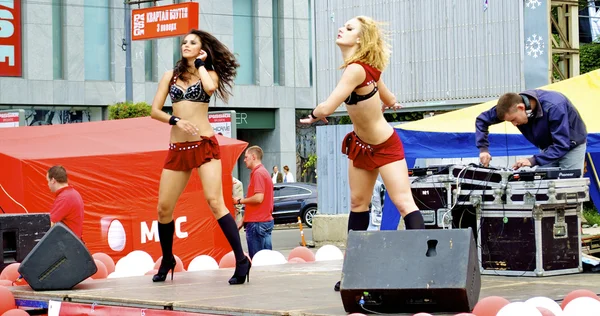 Two Russian sexy girls dance in red clothes during the city holiday and promotion of new brand — Stock Photo, Image