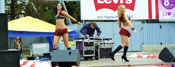 Sexual moves of two Russian sexy girls who dance in red clothes during the city holiday and promotion of new brand — Stock Photo, Image