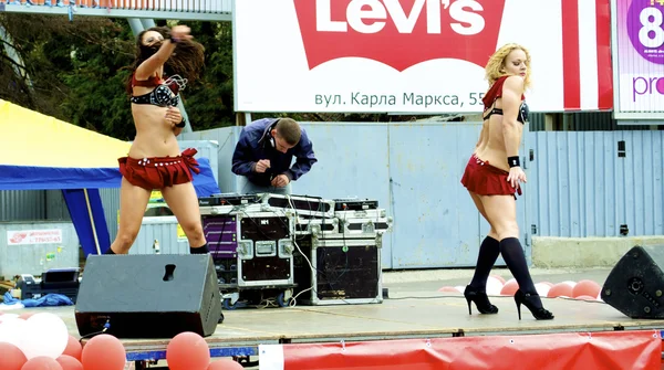 Sexual moves of two Russian sexy girls who dance in red clothes during the city holiday and promotion of new brand — Stock Photo, Image