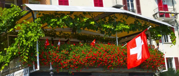 Balcony with roses and a Swiss flag — Stock Photo, Image