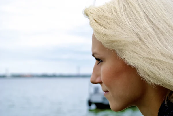 Prachtige blond Kaukasische model meisje kijkt op de rivier — Stockfoto