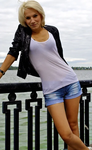 Κορίτσι όμορφο ξανθό μοντέλο καυκάσιος στο μαύρο μπουφάν και τζιν σορτσάκι — Φωτογραφία Αρχείου