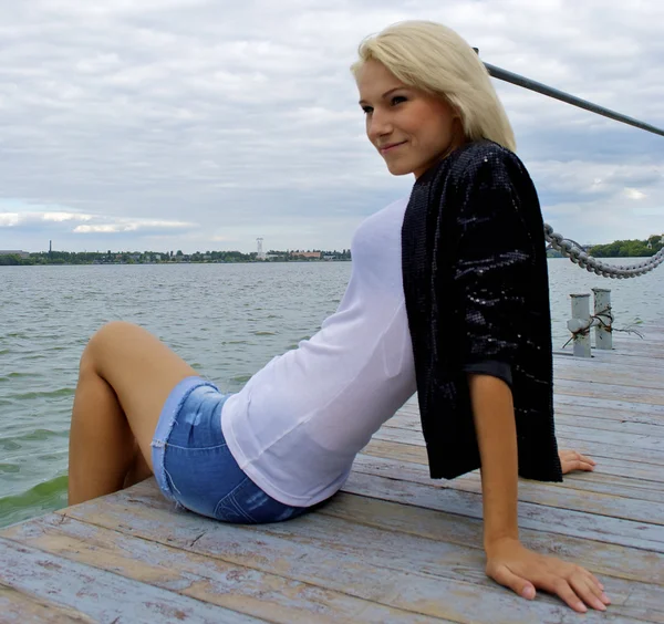 Schöne blonde kaukasische Modell Mädchen posiert auf der Seebrücke — Stockfoto