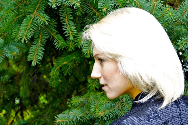 Piękny blond model kaukaski dziewczyna pozuje przed zielony świerk — Zdjęcie stockowe