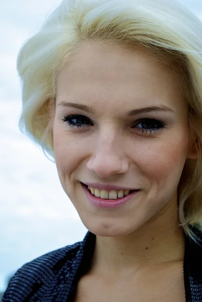 Gezicht van een meisje van de mooie blonde Kaukasische model voor de hemel — Stockfoto