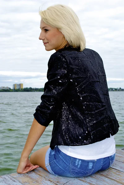 Nice blond caucasian model girl poses on the pier Stock Image