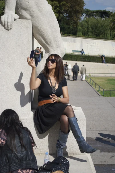 Girl in black takes photos — Stock Photo, Image