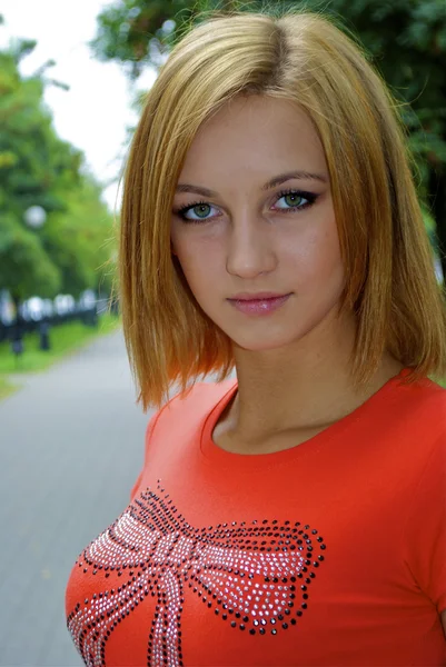 Retrato de una hermosa joven rubia sexual en una camisa naranja posa en — Foto de Stock