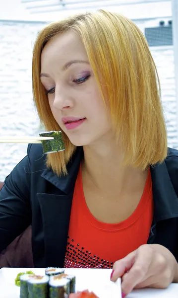 Hermosa chica bien vestida en el restaurante come sushi — Foto de Stock