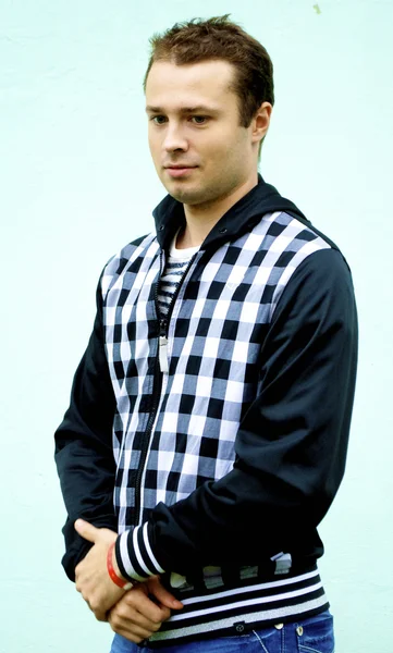 Young man poses in jeans and black jacket — Stock Photo, Image