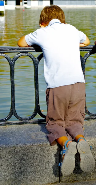 Ragazzo guarda oltre il lago — Foto Stock