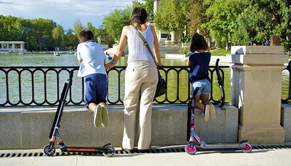 Moeder en haar kinderen kijken op het meer — Stockfoto