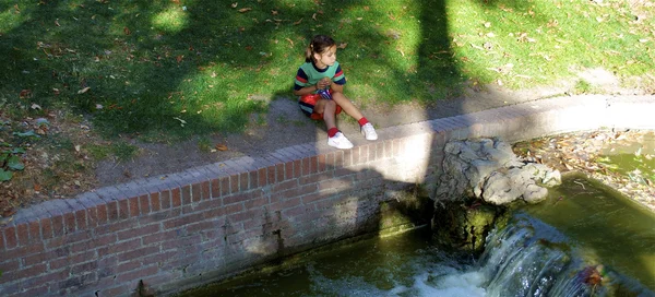 Pequeña linda chica española sobre la mini caída de agua —  Fotos de Stock