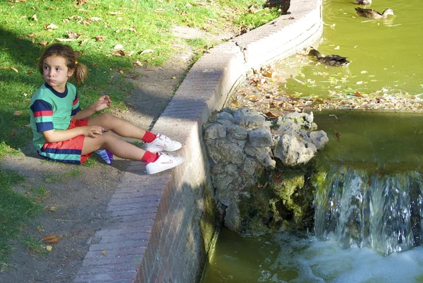 Pequeña linda chica española sobre la mini caída de agua — Foto de Stock