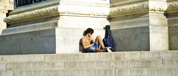 Napůl nahý muž bere odpočinek nedaleko památníku — Stock fotografie