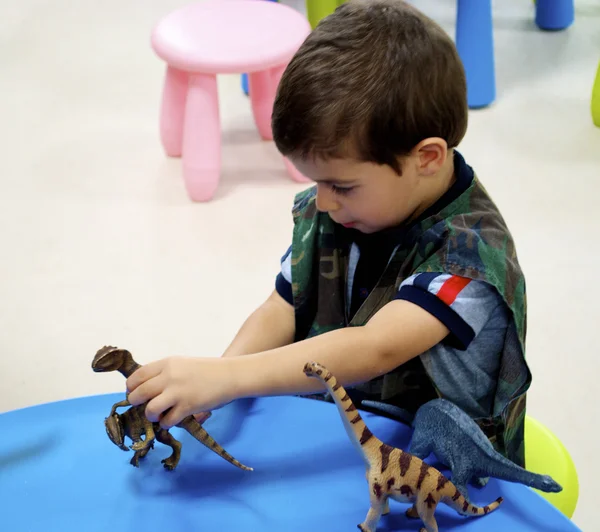 Pojke spelar i mini Jurassic område — Stockfoto