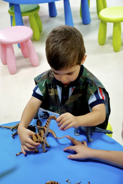 Pojke spelar i mini Jurassic område — Stockfoto